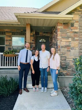 Jason with clients in front of their new home